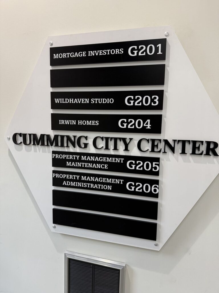 Cumming City Center tenant directory sign listing office suites including Mortgage Investors G201, Wildhaven Studio G203, Irwin Homes G204, and Property Management suites G205 and G206