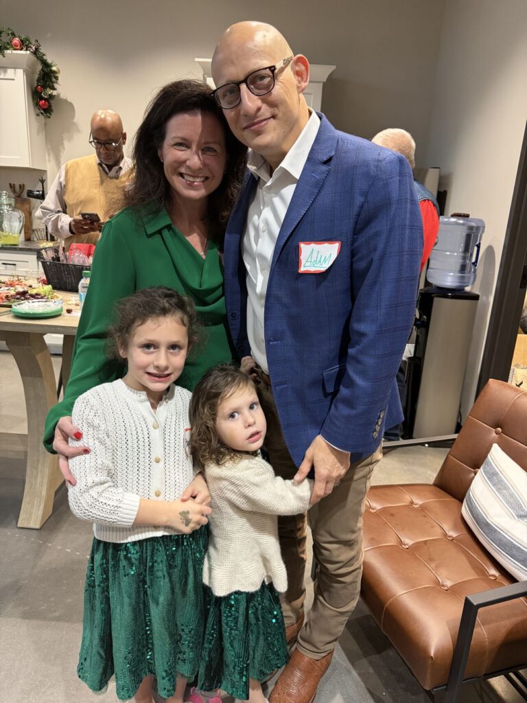 Adam Buice with his wife and two daughters at an office Christmas party